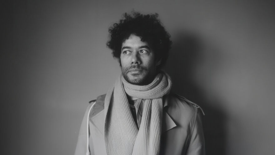 Richard Ayoade in a scarf and coat image in black and white