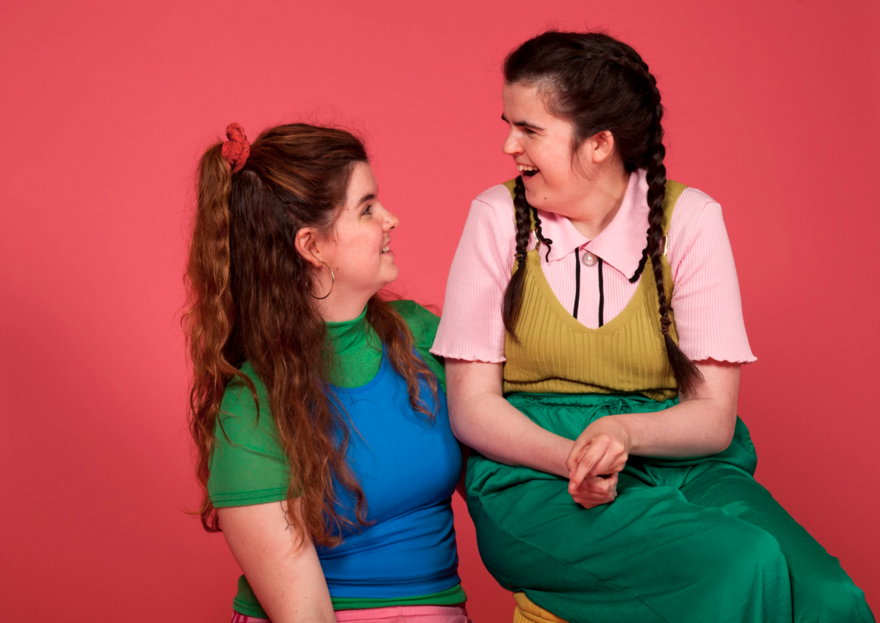Two women sat down looking at each other