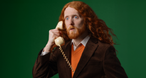 Alasdair Beckett King holding a telephone 