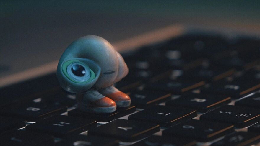 An animated shell with large eyes stands on a keyboard with shoes on.