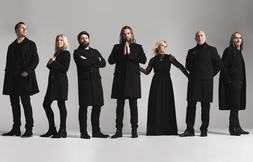 Five men and two women all wearing black standing in a line