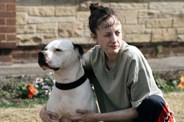 Woman kneeling holding a dog