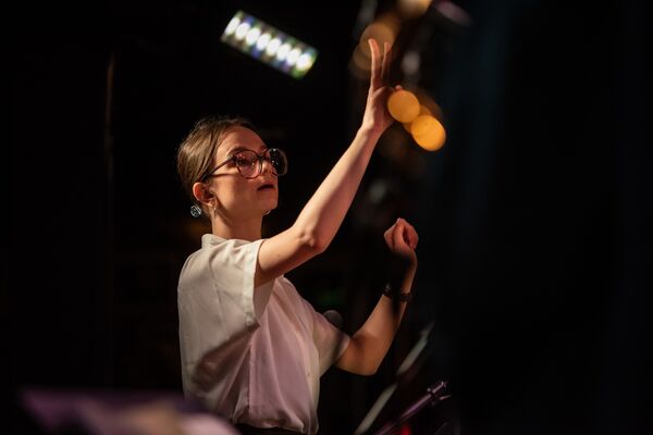 Young woman conducting with hands in the air