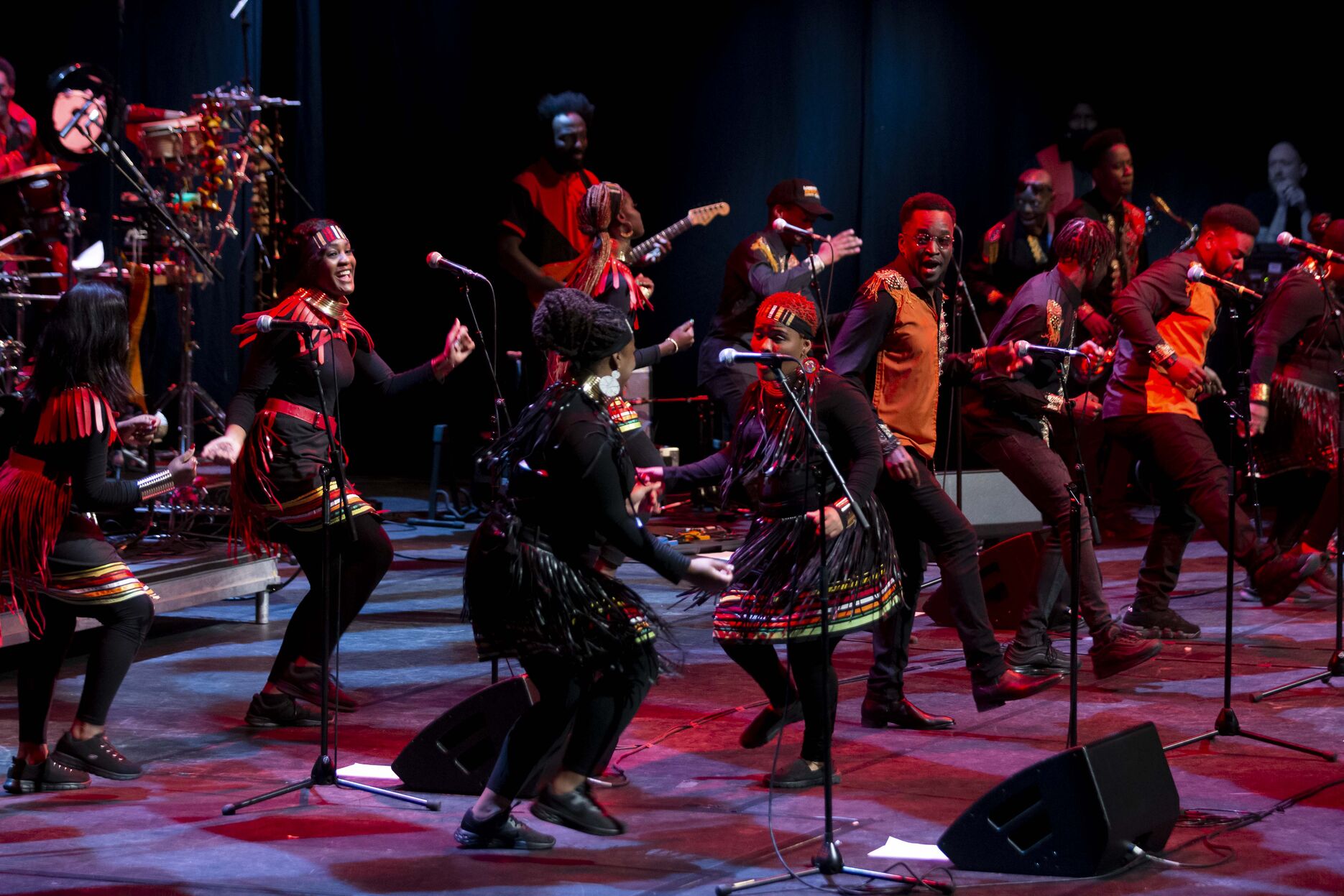 Performers on stage playing intstruments and dancing