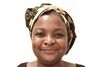 A headshot portrait of Loraine Masiya Mponela smiling warmly whilst wearing a patterned headscarf against a plain white background.