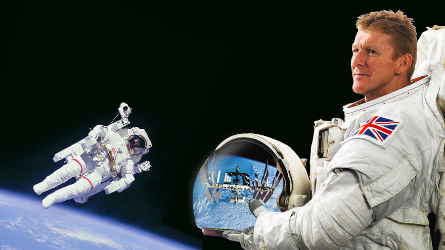 Tim Peake in a space suit holding a helmet
