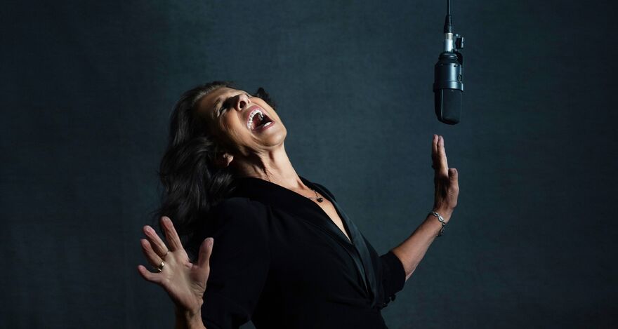 A studio portrait of singer Elkie Brooks performing passionately.