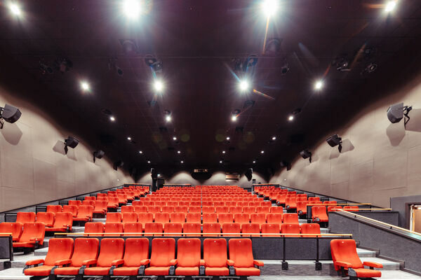 The red chairs in the cinema looking up towards the lights above