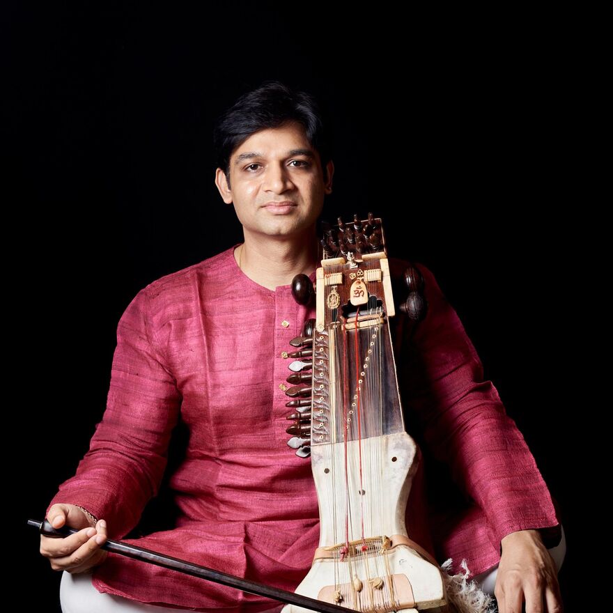 Harsh Narayan sitting with a Sarangi
