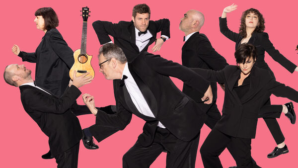 Member of the Ukulele Orchestra dancing with a pink background