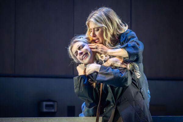 A woman embraces another woman in distress. 