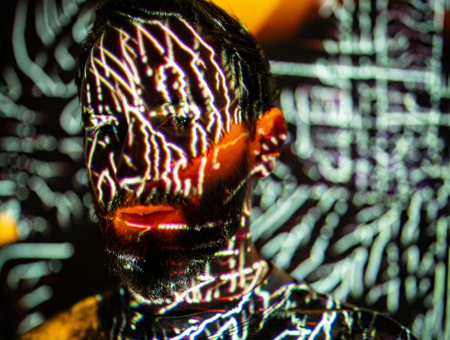 Max Cooper with white lights projected on his face