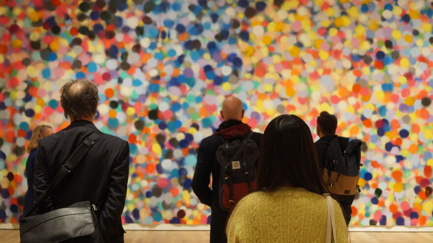 People standing looking at Rana Begum colourful artwork