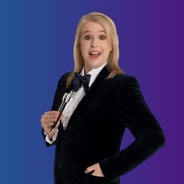 Hayley Ellis wearing a suit and bow tie holding a microphone
