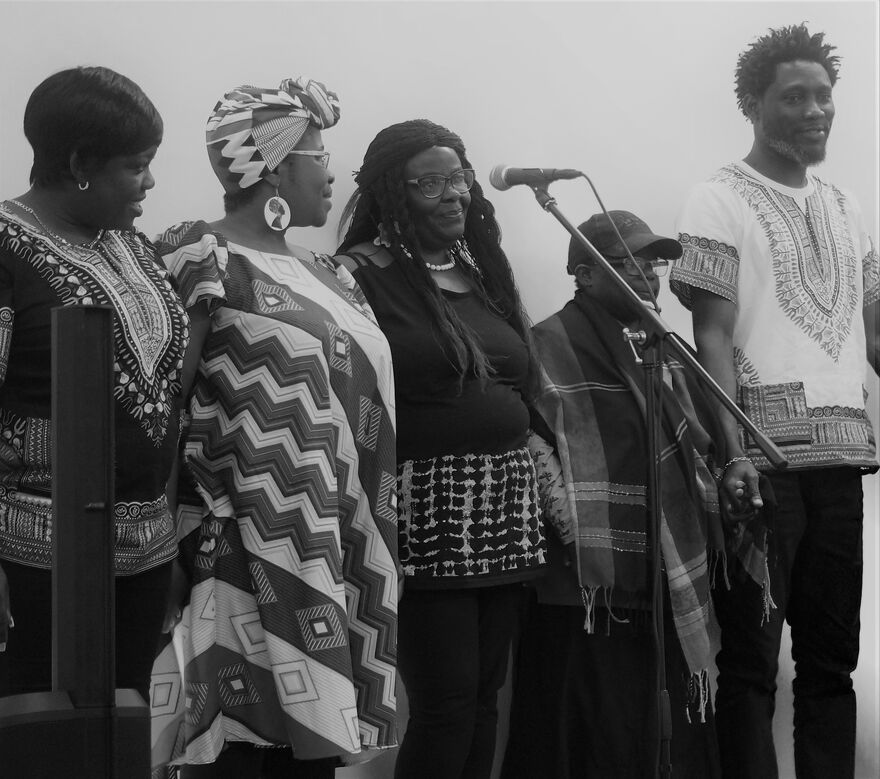 5 people stood with microphone in front, image in black and white
