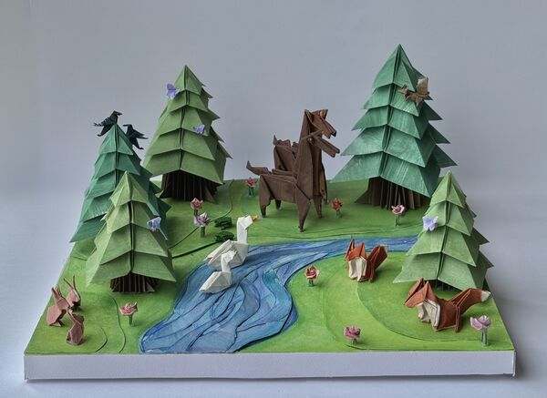 A detailed origami diorama of a forest landscape.