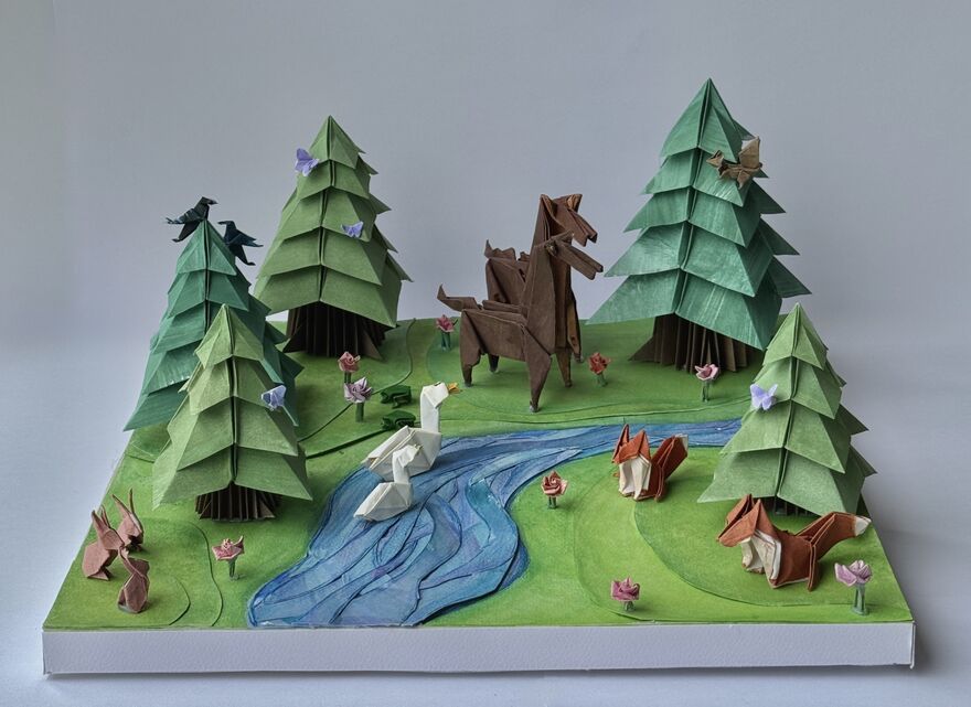 A detailed origami diorama of a forest landscape.