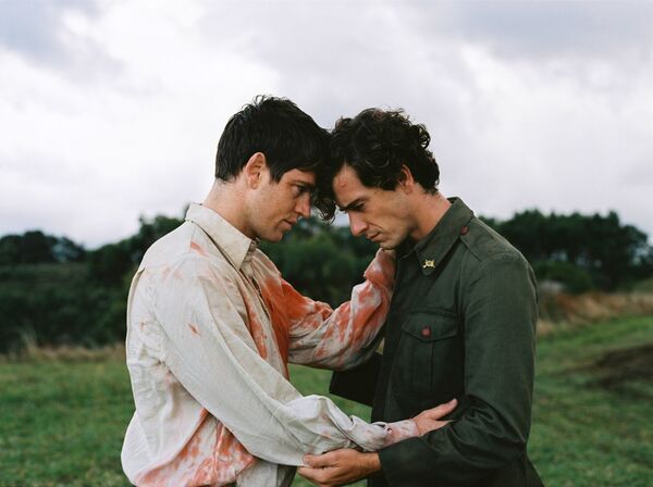 Two men embrace on a field. 