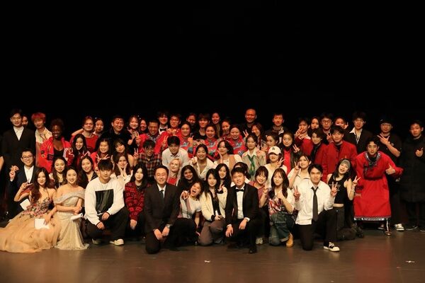 The Chinese Students and Scholars Association stand in a big group, looking at the camera. 