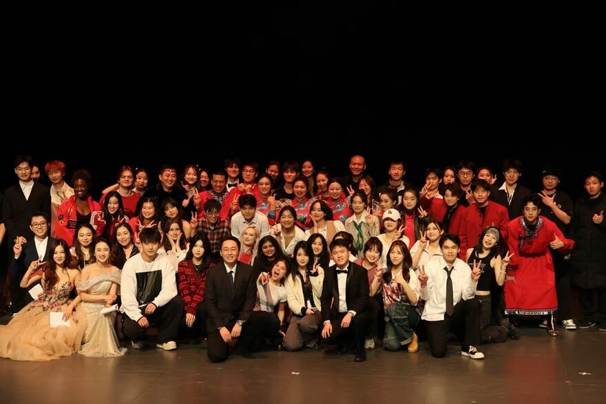 The Chinese Students and Scholars Association stand in a big group, looking at the camera. 