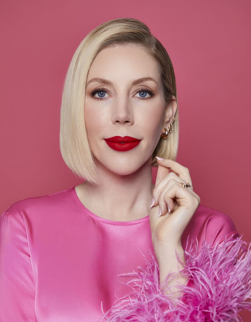 Katherine Ryan in a pink top won a pink background