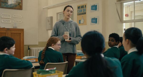A teacher talks to her pupils in a classroom. 