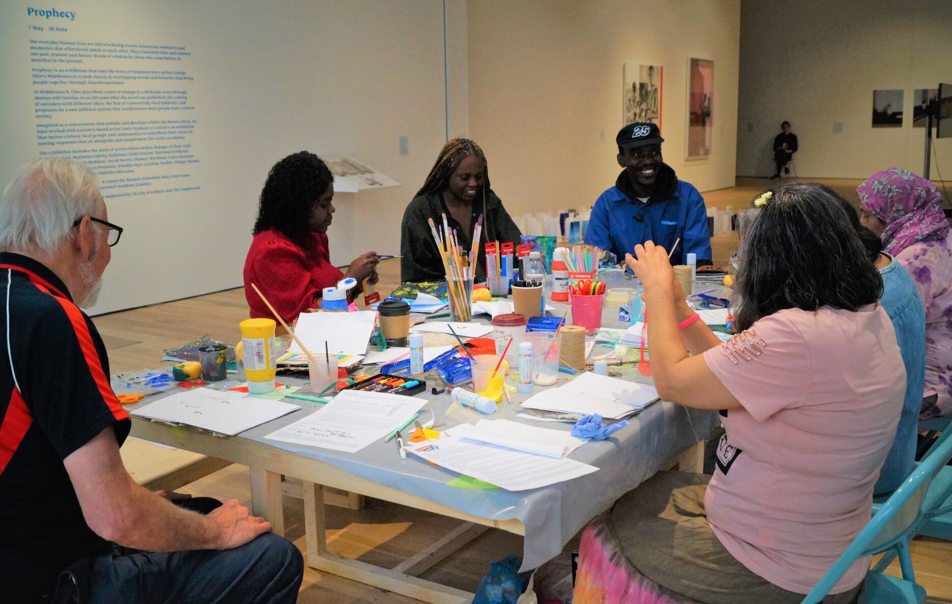 People sat around a table painting in gallery four space