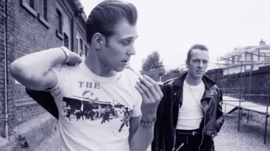 Members of the Clash walk down a street. 