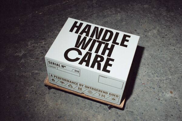 A White box with 'Handle with Care' win block capitals