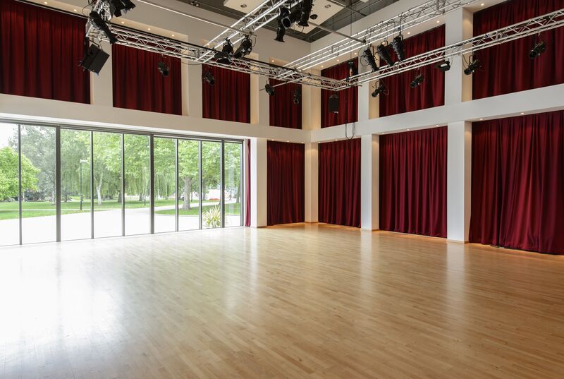 Empty room with a wall of large windows and wooden flooring