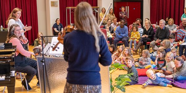 Band in front of families sat on matts and chairs