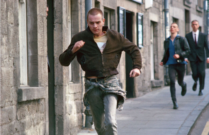 A young man being chased down a street. 
