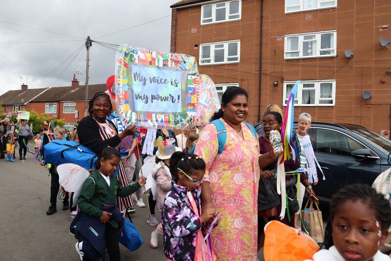 Two women lead a group of children down a residential street during the Canley parade.