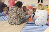 group of mums and children sat on the floor 