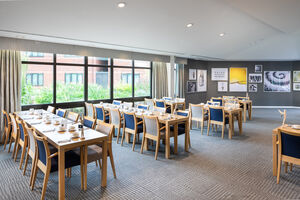 Rows of seating set for breakfast in a large dining area with bright windows