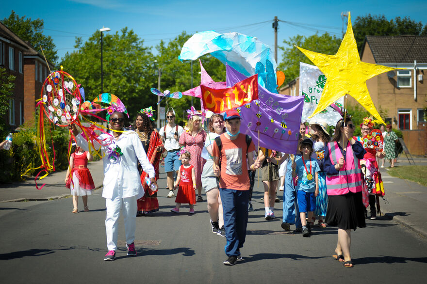 People walking with colourful banners and artwork