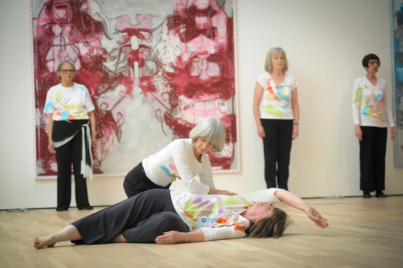 Elders dance performers performing in Mead Gallery, two dancers lyting on the floor, three standing against the wall