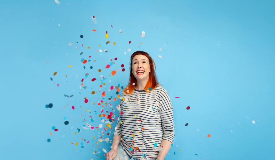 A woman in a stripey top surrounded by confetti