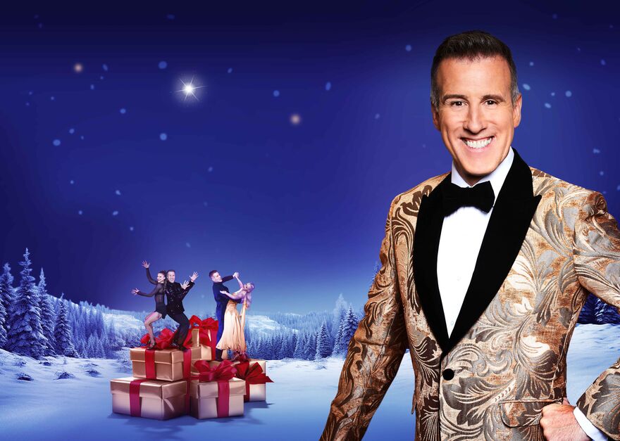 Designed image with Anton Du Beke in the foreground and two couples of dancers standing on Christmas presents