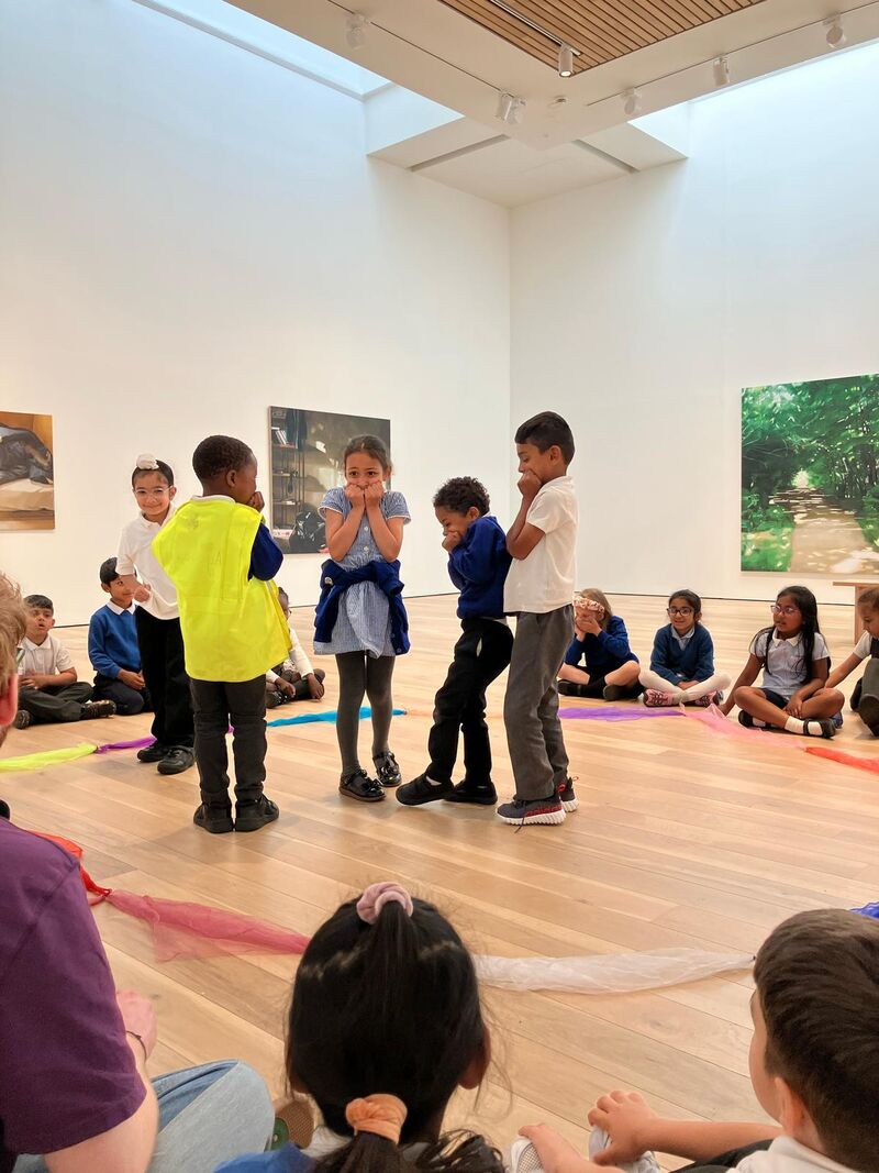 Children sat round in a circle with 5 stood in the middle of the circle
