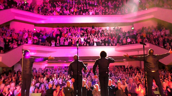 Backs of The Drifters on stage with the crowd