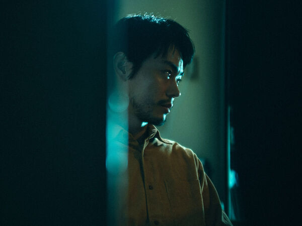A man can be seen through the crack of a doorway. 