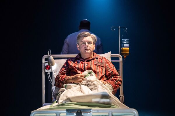 Michael Sheen as Nye Bevan sat in a hospital bed.