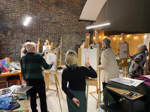 People stood in front of easls srawing 