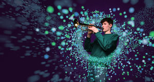 Teen boy playing trumpet surrounded by colourful blurred circles