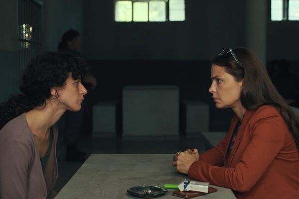 Twoo women sat across a table looking at eachother Twoo women sat across a table looking at eachother