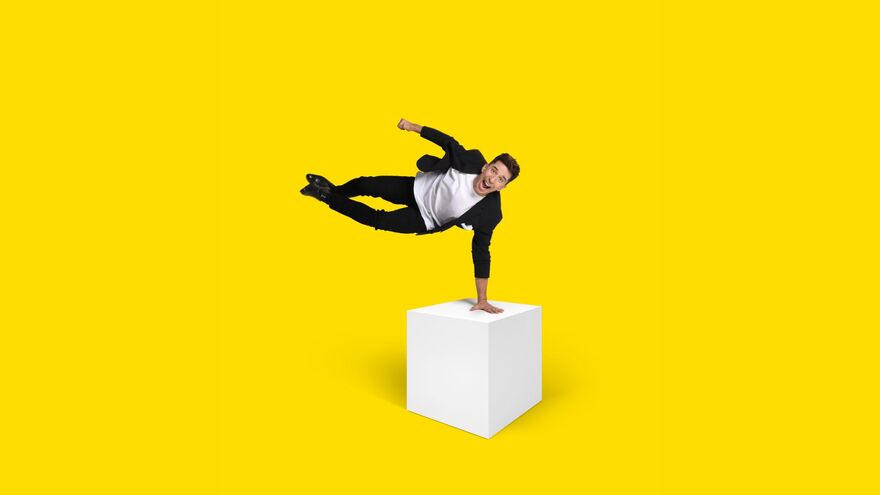Russell Kane jumping over a white box 