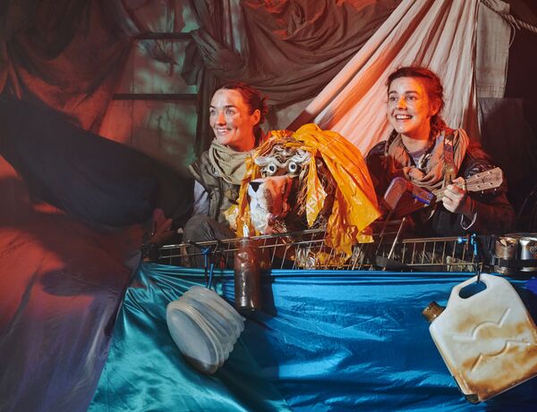 Two people on a make shift boat with a tiger puppet between them