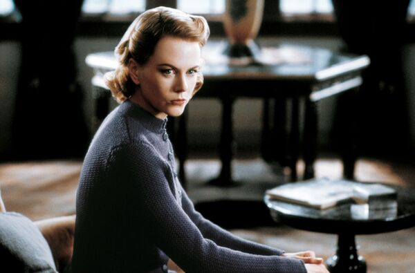 A woman with a stern stare sits. 