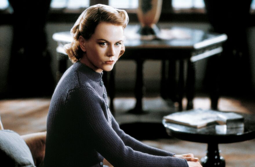 A woman with a stern stare sits. 